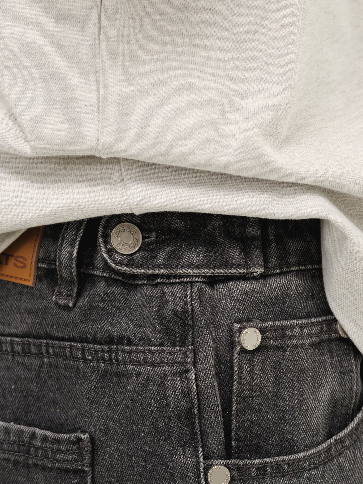 Washed black denim baggy jeans by Sweats EU displayed on a full-body mannequin, showcasing relaxed fit and casual style.