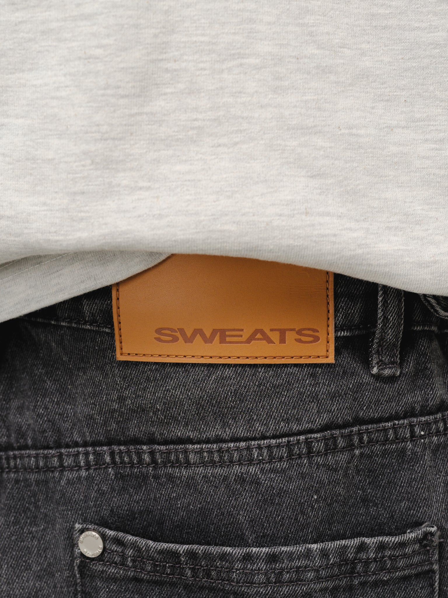 Washed black denim baggy jeans from SWEATS EU displayed on a model, showcasing relaxed fit and casual style.